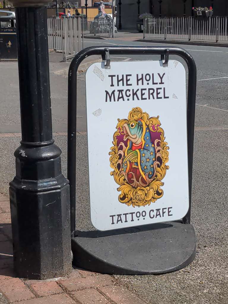 Holy Mackerel Tattoo Cafe sign showing a fish in robes