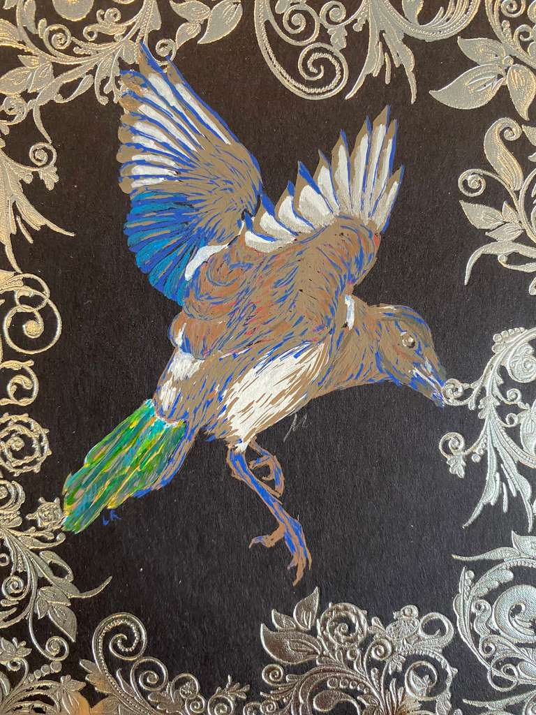 A bird in flight against an ornate black and silver background